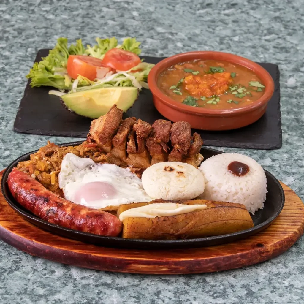 Bandeja paisa colombiana con chorizo, chicharrón, carne, huevo, aguacate, arroz y frijoles de El Establo en Valencia