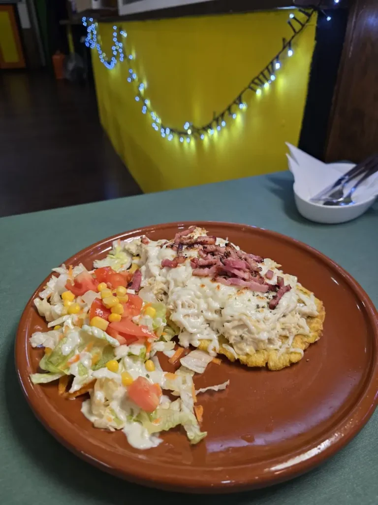 Patacón con pollo desmechado, salsa de la casa, bacon y queso de El Establo